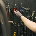 Homem organizando e armazenando ferramentas em painel de parede de forma segura