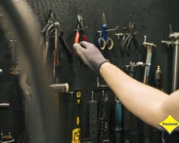 Homem organizando e armazenando ferramentas em painel de parede de forma segura