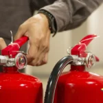 Profissional realizando manutenção preventiva de extintores durante inspeção técnica de segurança