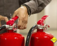 Profissional realizando manutenção preventiva de extintores durante inspeção técnica de segurança